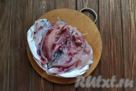 Лук и морковь очищаем. Голову толстолобика разрезаем на две части. Это легко сделать с помощью ножа, постукивая по нему молоточком. Кость тогда не дробится на мелкие щепки. Удаляем жабры, промываем под проточной водой и выкладываем в кастрюлю. Заливаем водой, добавляем половину луковицы и моркови. Ставим на огонь, после закипания уменьшаем огонь к минимуму и продолжаем варим 15-20 минут, периодически снимая образовавшуюся пену.
