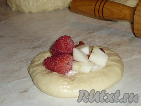 Каждую часть теста раскатать в лепёшку, в центр которой выложить фруктовую начинку и посыпать 0,5-1 чайной ложкой сахара (количество сахара регулируйте, в зависимости от сладости фруктов).&nbsp;
