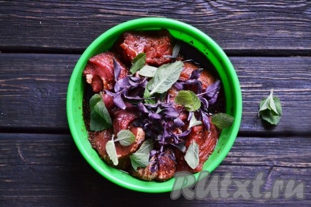 По желанию добавляем листики мяты и базилика. Все тщательно перемешиваем, накрываем пищевой пленкой и отправляем шашлык из свинины в холодильник минимум на 3 часа. Можно оставить его мариноваться в соевом соусе и меде и на сутки, от этого мясо станет только более мягким и нежным.
