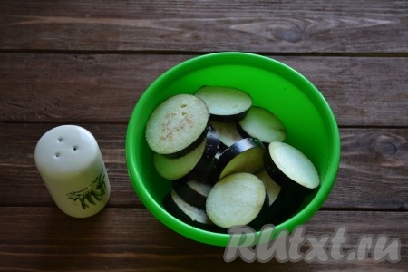 Баклажан моем, нарезаем кружочками (толщиной примерно 5 мм), посыпаем солью и оставляем на 30 минут. Затем необходимо стряхнуть нерастаявшую соль с баклажанов, а образовавшуюся жидкость слить.
