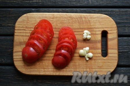 Нарезаем кольцами вымытые помидоры. Чеснок очищаем и пропускаем через пресс.
