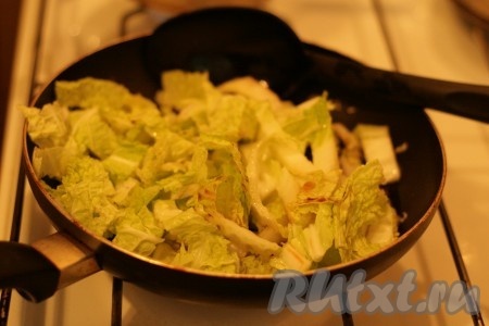 Добавить к обжаренным луку и чесноку пекинскую капусту, соевый соус и 3 столовые ложки воды.