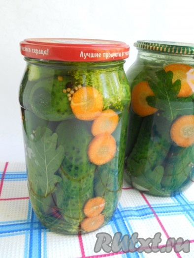 Далее залить огурцы кипятком, прикрыть крышками и оставить на 10 минут. Воду слить.