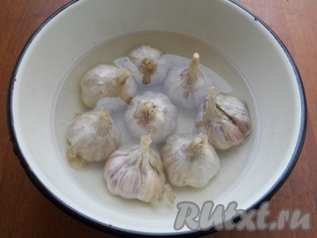 Головки чеснока залить кипятком на 2 минуты, затем воду слить и сразу же залить чеснок холодной водой. Таким образом чеснок хорошо очистится от верхней шелухи.