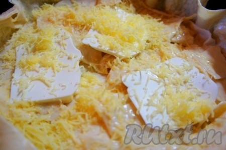 Выкладываем сыр фета, присыпаем тёртым сыром и накрываем первой круглой заготовкой из лаваша, смоченной в кефире. Аналогично повторите тоже самое до второй круглой заготовки.