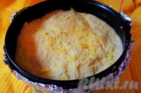 Оставленные припуски лаваша на бока аккуратно заправить под вторую круглую заготовку. Смазать обильно верх кефирно-яичным соусом, присыпать тёртым сыром.