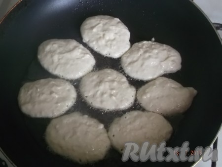 Ставим сковороду на средний огонь, наливаем растительное масло, очень хорошо разогреваем его и столовой ложкой выкладываем наше тесто, формируя оладьи. Я беру по 1 столовой ложке теста на каждый оладушек. Жарим оладьи с яблоками на среднем огне с двух сторон до подрумянивая. Затем перекладываем на тарелку. Тесто в миске перемешиваем, постепенно жарим все оладьи.