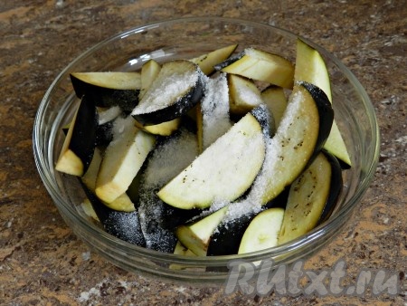 Баклажаны нарезать на кружочки (или полукружочки). Тонко нарезать баклажаны не нужно. Сложить нарезанные баклажаны в миску, посыпать солью, перемешать и оставить на 15-20 минут. Затем смыть соль под проточной водой, отжать с баклажанов лишнюю воду.