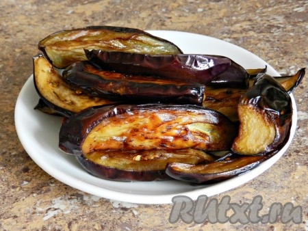 На сковороде разогреть растительное масло. Выкладывать баклажаны в один слой (все баклажаны сразу не поместятся в сковороду, поэтому жарить их нужно будет в несколько заходов) и обжаривать их на среднем огне с двух сторон до золотистой корочки. Жареные баклажаны со сковороды выкладывать на салфетку, чтобы стекло масло. Постепенно пожарить все баклажаны.