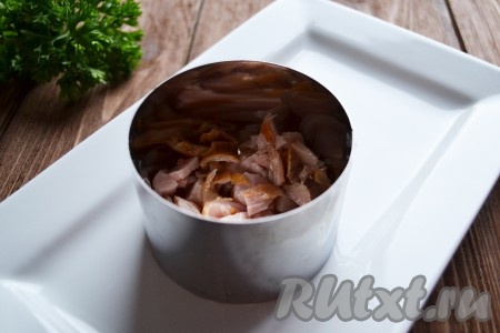 Первым слоем в формовочное кольцо выкладываем нарезанную копчёную курицу.
