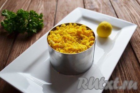 Последним слоем выкладываем натертый яичный желток. Салат накрываем пищевой пленкой и отправляем в холодильник, минимум на 30 минут.
