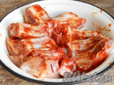 Подготовленные свиные ребрышки натереть маринадом со всех сторон.