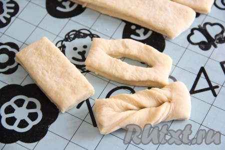 Затем сформировать вергуны, для этого длинные полоски нужно нарезать на полоски длиной примерно 6 сантиметров. В середине каждой получившейся полоски сделать надрез. Вывернуть край каждой полоски один раз через разрез, формируя вергуны.