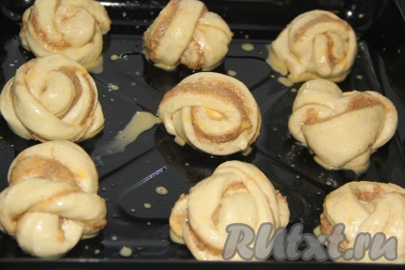 Подошедшие дрожжевые булочки с корицей и сахаром смазать взбитым ячным желтком и поставить в духовку, разогретую до 200 градусов, примерно на 25-30 минут.&nbsp;
