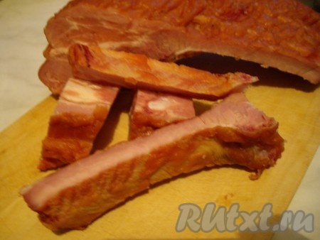 Копчёные свиные ребрышки нарезать на кусочки.
