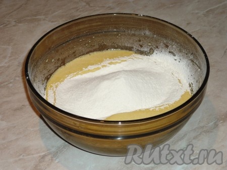 Добавить просеянную муку с разрыхлителем, растопленное и остывшее сливочное масло. Взбить миксером. Тесто должно быть однородным, без комочков и напоминать густую сметану.&nbsp;
