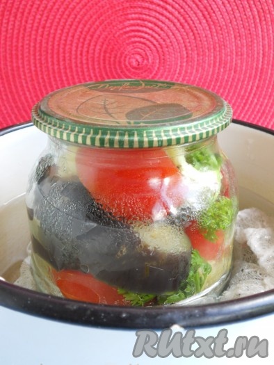 В банку всыпать соль и влить растительное масло. В большой кастрюле вскипятить воду, выложив на дно кастрюли полотенце или марлю, сложенную втрое. Аккуратно поместить в кастрюлю банку с баклажанами и овощами. Прикрыть кастрюлю сверху прокипяченной крышкой. Очень важно, чтобы вода в кастрюле доходила до плечиков банки! Стерилизовать на среднем огне от начала кипения воды - 40 минут. В процессе стерилизации вода будет выкипать, поэтому следует доливать в кастрюлю кипяток. 
