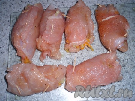 Сформировать рулетики: на каждый отбитый кусочек филе индейки выложить остывшую начинку, сыр, свернуть рулетом и скрепить зубочистками.