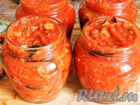 Разложить баклажаны в томатном соусе по стерилизованным банкам, накрыть прокипяченными крышками. Банки перевернуть, укутать одеялом и оставить до полного остывания. Затем убрать для хранения. Закуска получается очень вкусной, пикантной и прекрасно разнообразит зимнее меню.