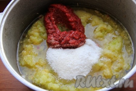 К кабачкам добавить сахар, соль, перец, растительное масло и томатную пасту. Все перемешать и отправить на огонь, после закипания огонь уменьшить и варить аджику 40-50 минут, иногда перемешивая.
