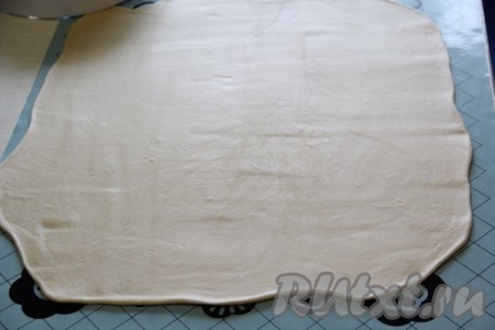 Готовое тесто достать из холодильника и раскатать на силиконовом коврике или на столе, присыпанном мукой, в тонкий прямоугольный пласт.
