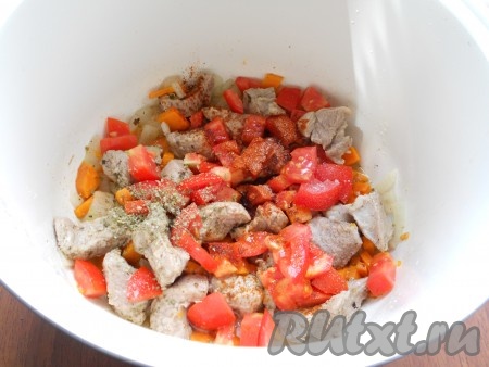 Далее выложить свежие помидоры, нарезанные кубиками, добавить майоран, соль и красный молотый перец, влить горячую воду и выставить режим "Тушение" на 40 минут.
