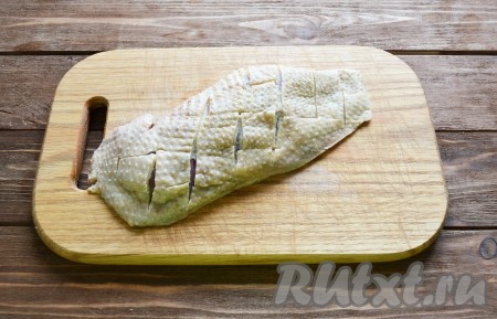 Обе половинки грудки моем, затем убираем лишнюю жидкость салфетками. Делаем на коже надрезы крест-накрест (благодаря надрезам на коже, жир будет лучше вытапливаться и грудка лучше прожарится).
