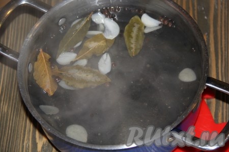 В кастрюлю влить воду, добавить соль, перец, лавровые листья и чеснок. Поставить кастрюлю на огонь и довести до кипения. Прокипятить рассол пару минут, а затем снять с огня.
