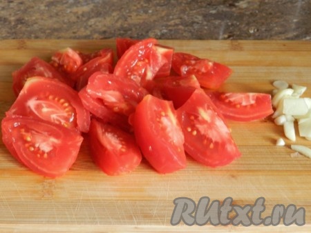 Чеснок нарубить ножом. С помидоров снять кожицу и нарезать на четвертинки.