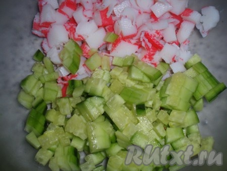 Огурец нарезать небольшими кубиками, добавить к нему мелко нарезанные крабовые палочки.
