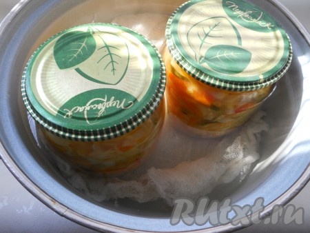 В большой кастрюле нагреть воду почти до кипения, на дно поместить тряпочку или марлю, сложенную втрое. Аккуратно поставить в горячую воду банки с салатом. Вода должна доходить до "плечиков" банок. После закипания воды стерилизовать 0,5-литровые банки - 5 минут, литровые - 10 минут.
