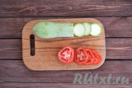 Для приготовления овощного рататуя лучше взять молодые кабачки с мелкими семечками. Кабачки и помидоры вымыть, обсушить и нарезать кружочками.
