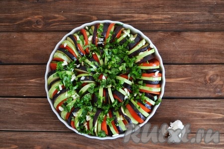 Чеснок очистить, мелко нарезать и посыпать им овощи. Петрушку мелко нарезать, посыпать овощи петрушкой, посолить по вкусу и отправить рататуй из кабачков, баклажанов и помидоров в духовку, разогретую до 180 градусов, на 1 час.
