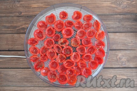 Выкладываем помидоры на поддон электросушилки, посыпаем травами и взбрызгиваем маслом.&nbsp;
