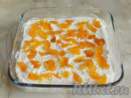 В форму для выпечки (у меня размер формы 20х20 см) выложить немного приготовленного крема. Печенье савоярди, окунув в сироп, выложить на крем. Сверху нанести слой крема и разложить нарезанные мандарины.