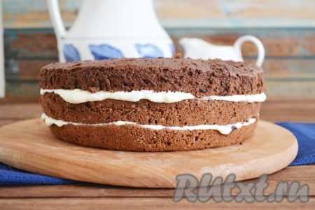 Смазала каждый корж кремом, приготовленным из творога, белого шоколада и сливочного масла, а между коржами выложила вишню без косточек. Собрала торт, смазав верх кремом.
