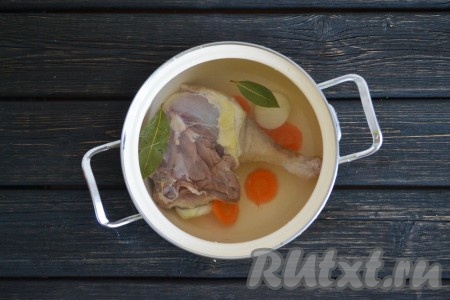 Мясо гуся выкладываем в кастрюлю, добавляем половинку нарезанной кружочками моркови, одну луковицу и листики лавра. Заливаем водой и ставим на огонь. После закипания огонь делаем минимальным и продолжаем варить до готовности. Это займет 45-60 минут. Во время кипения нужно снимать образовавшуюся пену.
