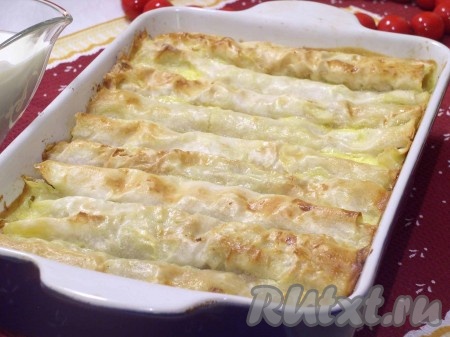 В форму, смазанную маслом, выкладываем трубочки из лаваша с начинкой. Сверху трубочки смазываем соусом, а также заливаем соус в концы трубочек. При запекании соус схватится и "запечатает" трубочки. Отправляем в духовку, разогретую до 180 градусов, на 15-25 минут, запекаем до золотистого цвета.
