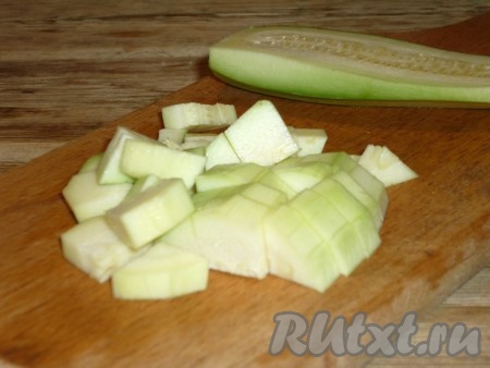 К обжаренному луку добавить очищенные от кожуры и нарезанные средними кубиками кабачки.