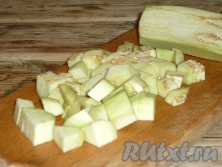 К луку добавить очищенные от кожуры и нарезанные средними кубиками баклажаны.