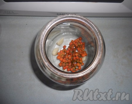 Помидоры вымыть. В простерилизованную банку (у меня полтора-литровые банки)&nbsp;на дно выложить чеснок и рябину.