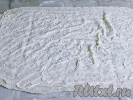 Лаваш, разложив на столе, смазать тонким слоем майонеза, оставляя края не смазанными.
