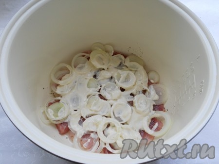 Смазать мясо с луком сметаной.