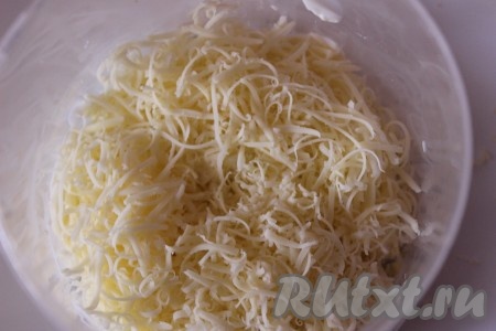 Поверх салата из курицы, шампиньонов и яиц пышной шапкой разложить натертый на мелкой терке сыр. Накрыть салат пищевой пленкой и отправить в холодильник на пару часов.
