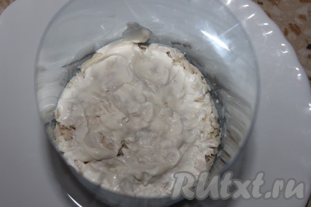 Начинаем собирать салат. На плоскую тарелку поставить кулинарное кольцо для формирования салата (кулинарное кольцо можно сделать и в домашних условиях, обрезав пластиковую бутылку). На дно тарелки выложить куриное мясо, слегка утрамбовать, сделать майонезную сеточку.
