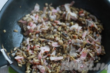 К грибам отправьте нарезанный бекон, немного обжарьте.
