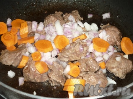 Лук и морковь очистить, лук нарезать кубиками, морковь - кружочками. Отправить нарезанные овощи к мясу. Готовить 3-4 минуты, периодически перемешивая, пока лук не станет прозрачным. 
