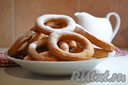Подсолнечное масло хорошо нагреть во фритюрнице или обычной кастрюле. Выкладывать в нагретое масло по несколько пончиков. Это нужно делать очень аккуратно, чтобы не брызнуло масло. Обжаривать пончики с двух сторон до золотистого цвета (примерно по 1 минуте), после выложить на салфетку, чтобы ушло лишнее масло. Перед подачей, по желанию, наивкуснейшие, мягкие пончики, замешанные на молоке и дрожжах, посыпать сахарной пудрой.

