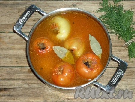 Залить в кастрюлю воду так, чтобы она полностью покрывала фаршированные перцы, добавить лавровый лист, соль и чёрный перец горошком. Отправить кастрюлю на огонь, довести до кипения, накрыть крышкой и готовить на небольшом огне 30 минут.&nbsp;
