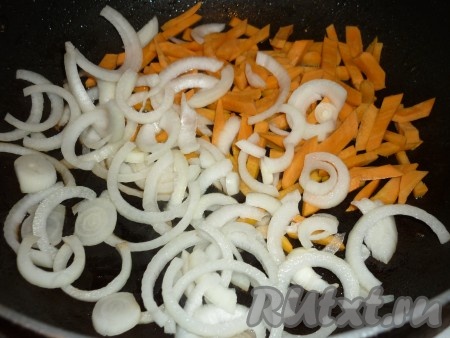 Обжаренную свинину переложить в толстостенную кастрюлю, в которой мы будем тушить блюдо. А на оставшемся в сковороде растительном масле обжарить нарезанный полукольцами лук и нарезанную брусочками морковь. 